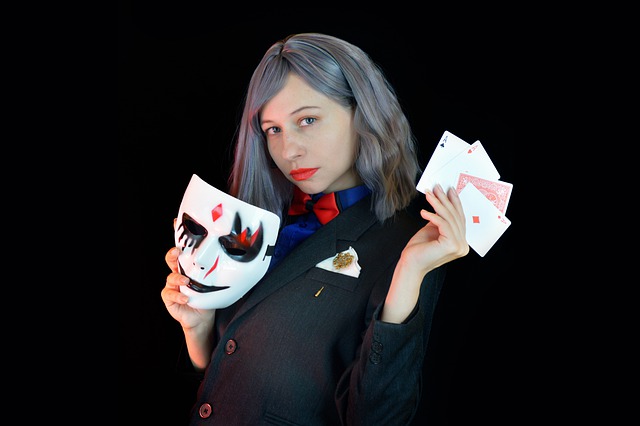woman with playing cards and mask on hands