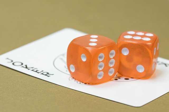joker card with two orange dice